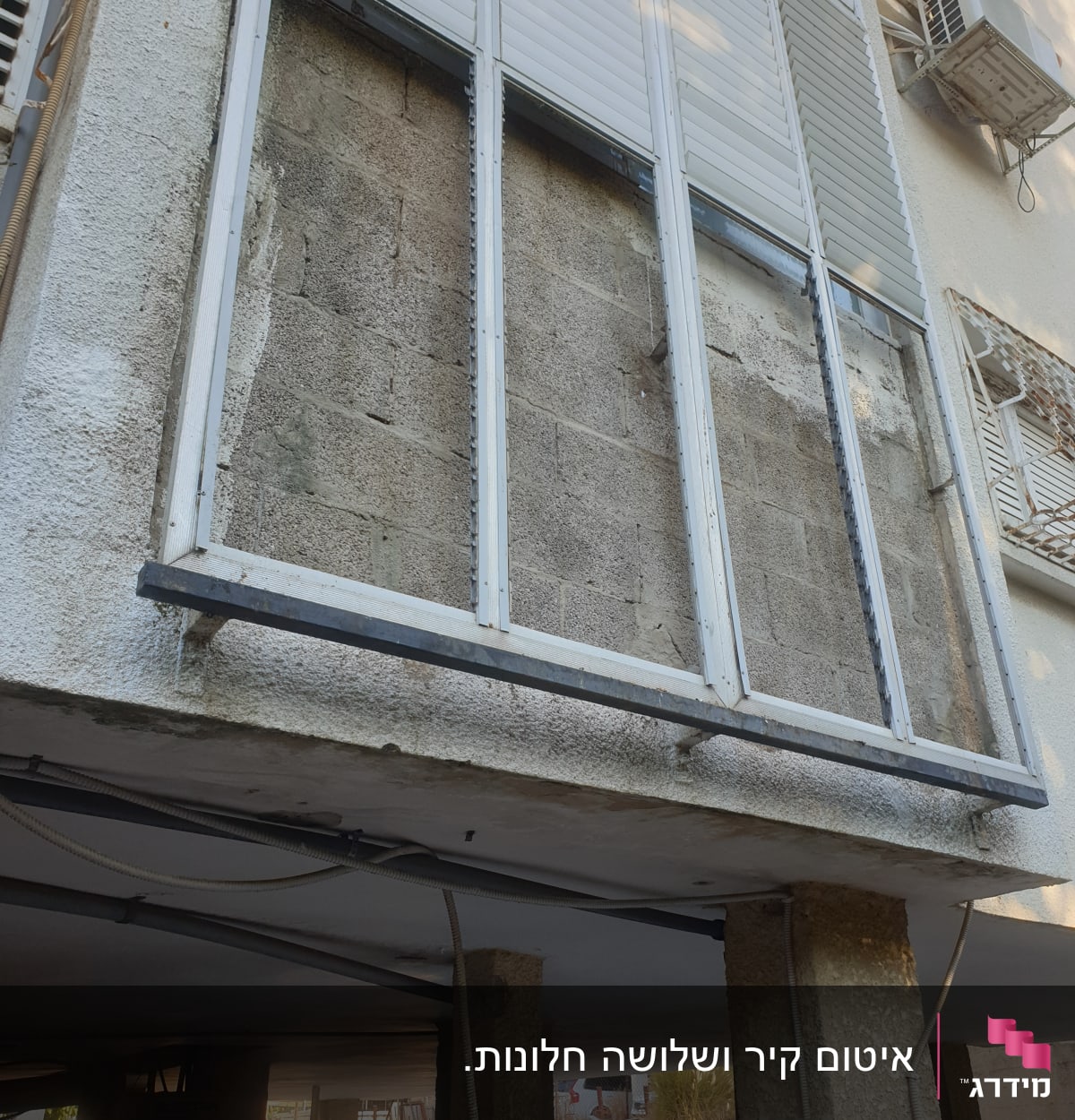 קיר בטון עם מסגרות חלונות ללא זכוכית